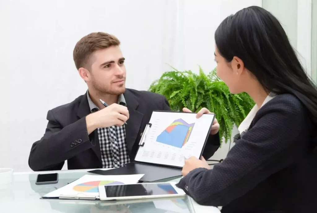 Conseiller en énergie présentant une analyse graphique à une cliente lors d’un rendez-vous de conseil