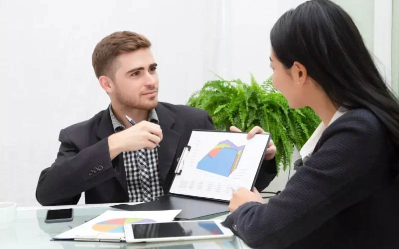 Conseiller en énergie présentant une analyse graphique à une cliente lors d’un rendez-vous de conseil